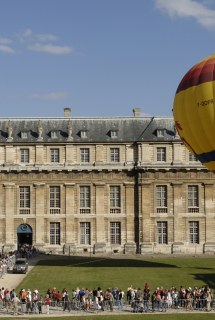 On voit une mongolfière devant le pavillon du Roi, au château de Vincennes, et une foule faisant la queue pour y accéder