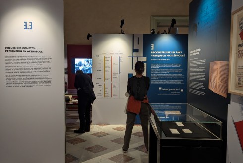 Des visiteurs regardent les panneaux et vitrines de l'exposition
